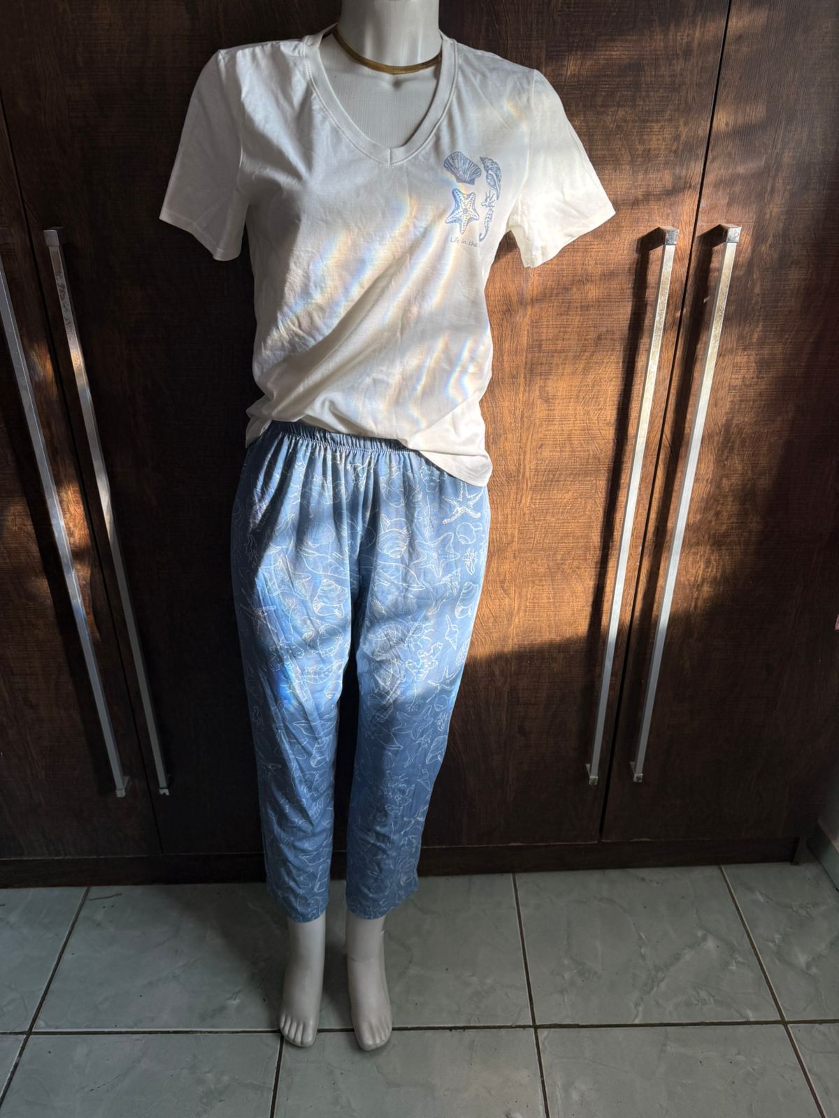 Foto caseira de um conjunto de blusa e calça em um manequim